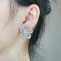 Silver flower stud earrings on ear