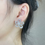 Silver flower stud earrings on ear