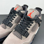 Two Air Jordan 4 sneakers in taupe with black laces, mesh panels, and red logo hits
