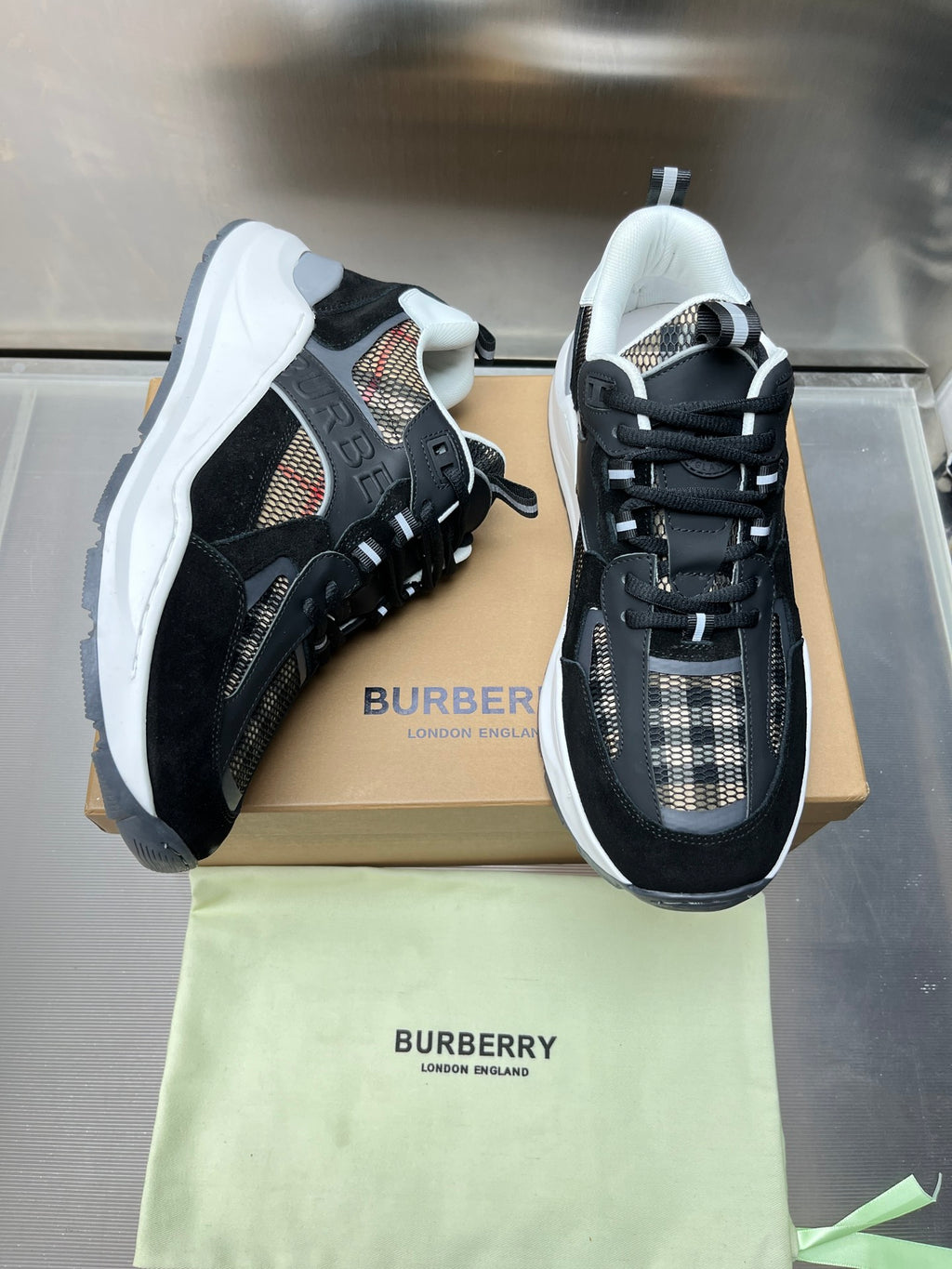 Black and gray lace-up sneakers with check panels and white midsoles