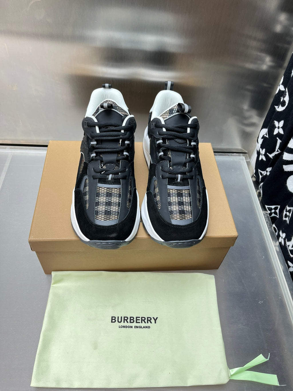 Pair of black lace-up sneakers with check fabric detail and white trim