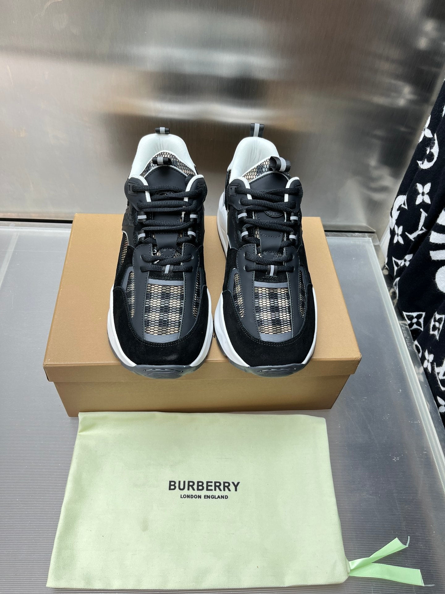 Pair of black lace-up sneakers with check fabric detail and white trim
