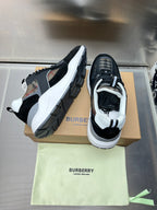 Black low-top sneakers with white soles and check-textile side panels
