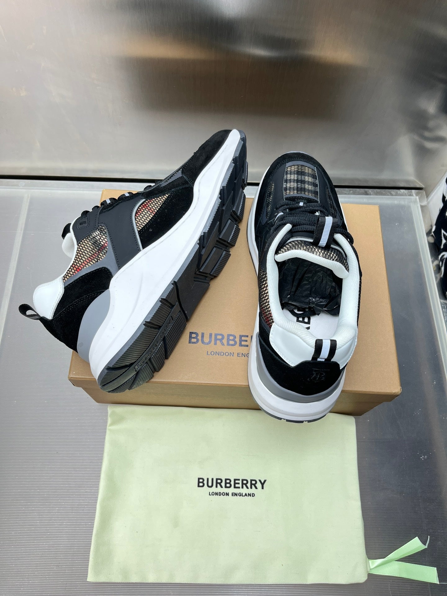 Black low-top sneakers with white soles and check-textile side panels