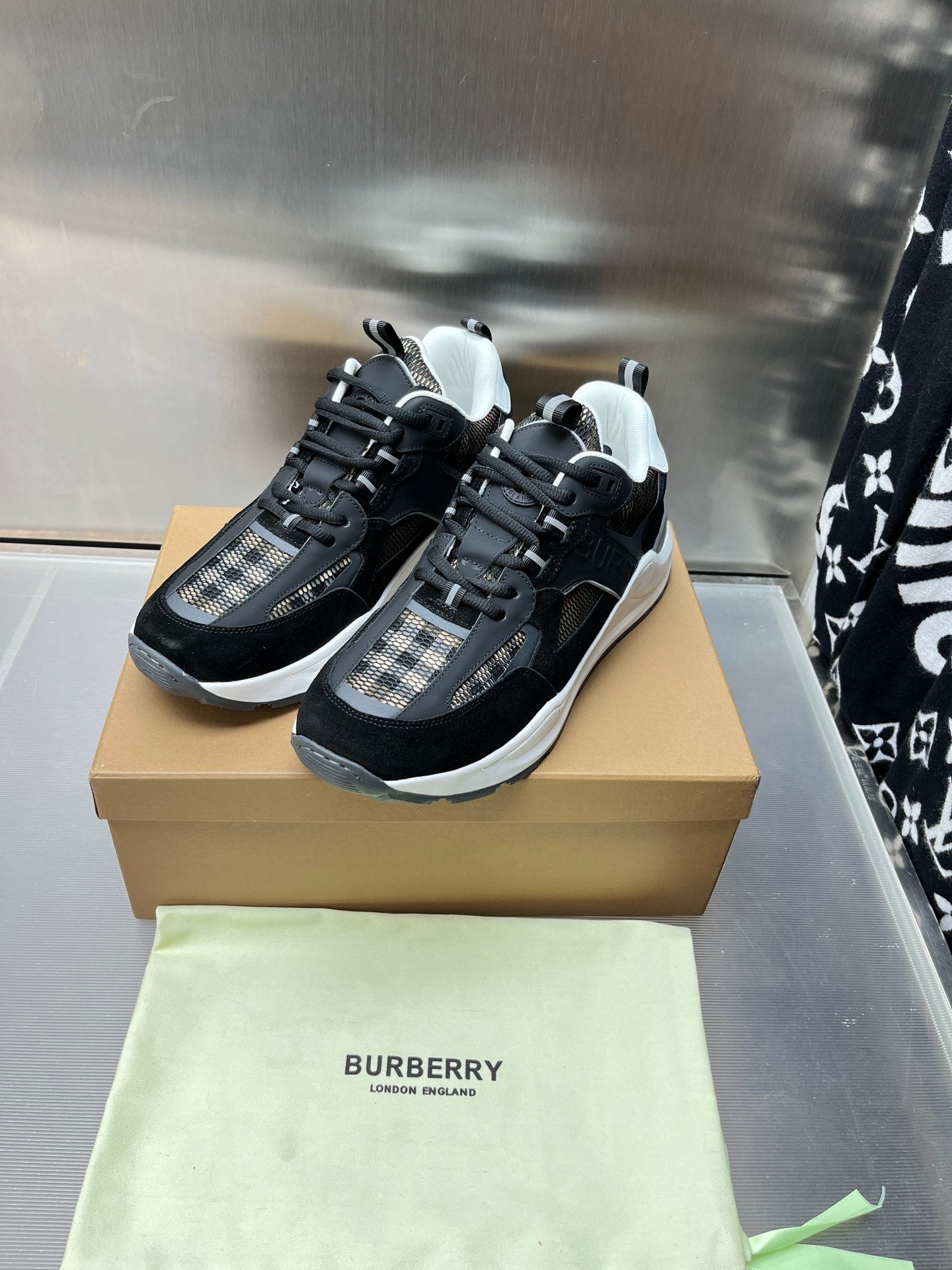 Black lace-up sneakers with check-textile side panels and white rubber soles