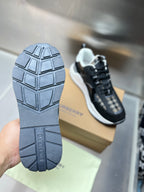 Sneaker outsole with tread and Burberry text, black rubber bottom