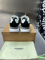 Black sneakers with white midsoles and rear logo accents, lace-up