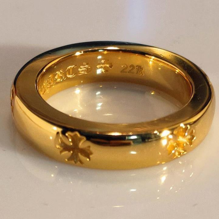 Gold-colored ring with glossy finish and engraved floral pattern around the band.