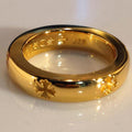 Gold-colored ring with glossy finish and engraved floral pattern around the band.