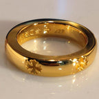 Gold-colored ring with glossy finish and engraved floral pattern around the band.