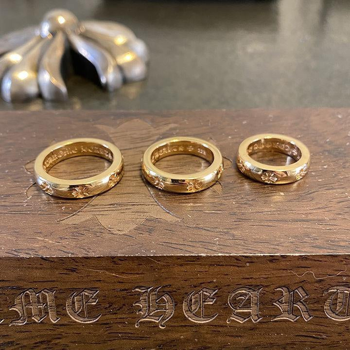 Set of three gold-colored rings with engraved floral details on the band.