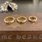 Set of three gold-colored rings with engraved floral details on the band.