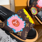 Louis Vuitton slide sandal with dark monogram strap and pink flower patch with blue trim