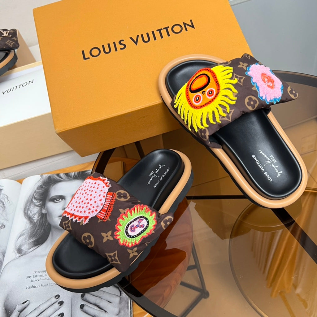 Louis Vuitton slide sandals with dark monogram straps and red flower and rainbow emblem motifs