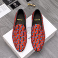Versace luxury slip-on shoes, orange and blue geometric logo pattern, black trim