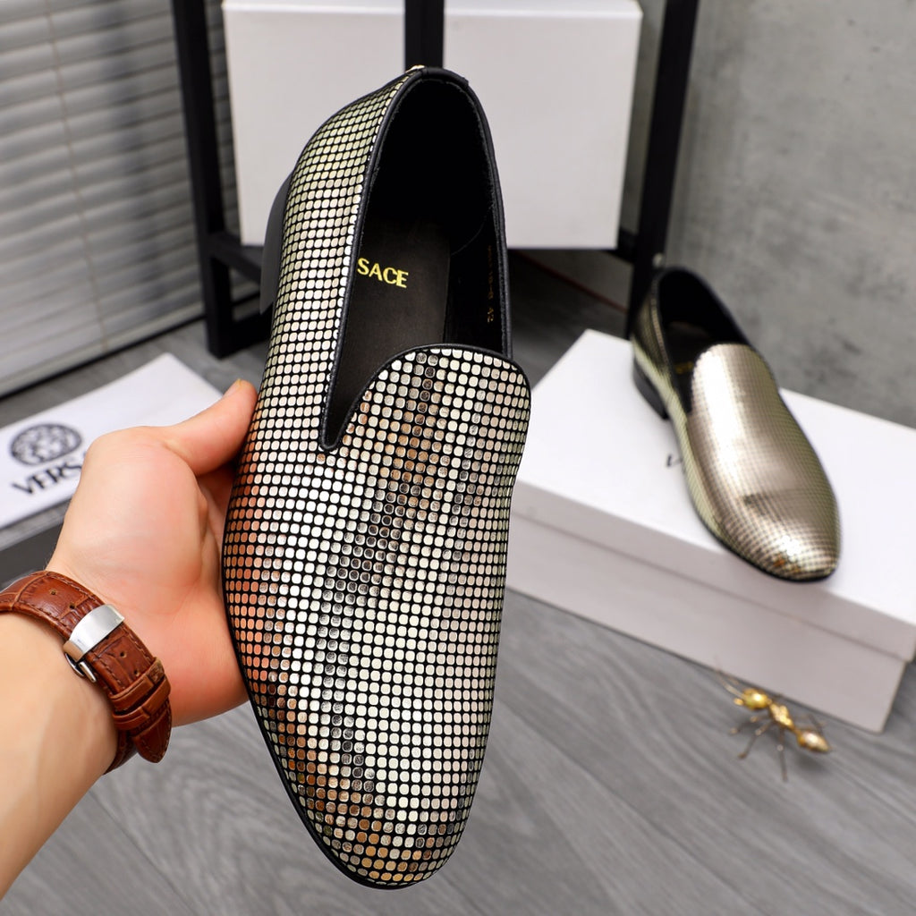 Gold and white rhinestone dress loafer with black lining, held in hand