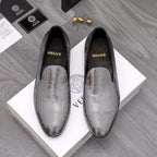 Rhinestone slip-on loafers with black uppers and pointed toe, gold emblem detail