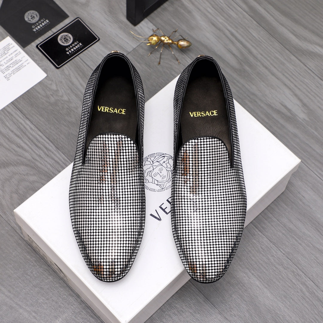 Rhinestone slip-on loafers with black uppers and pointed toe, gold emblem detail