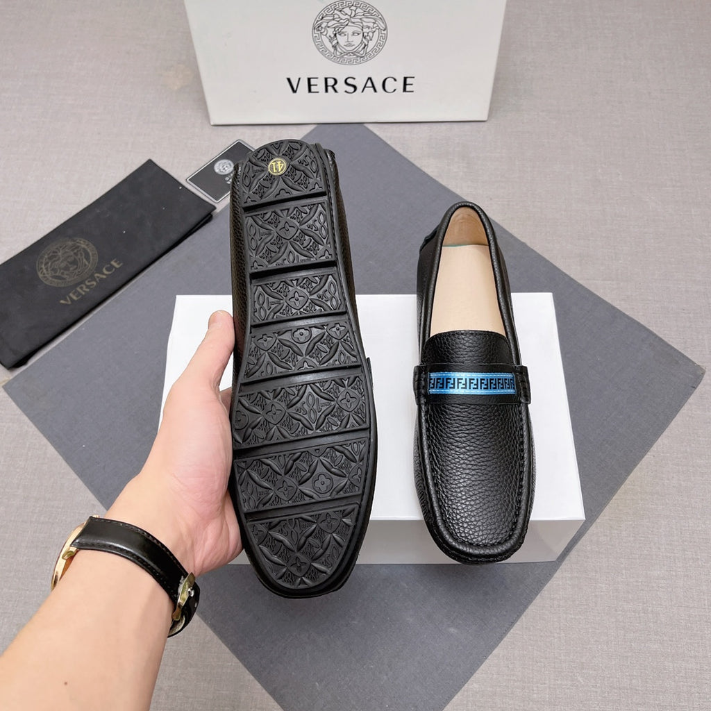 Black leather loafers with blue logo band, patterned outsole underside shown