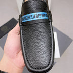 Black leather loafer with blue logo band across vamp, textured grain