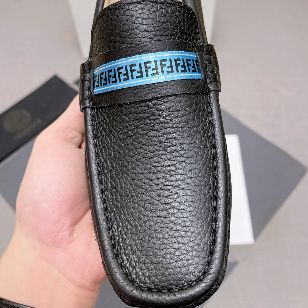 Black leather loafer with blue logo band across vamp, textured grain