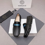 Black leather loafers with blue logo band and rubber sole, side view