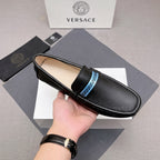Black leather loafer with blue logo band on upper, beige lining visible