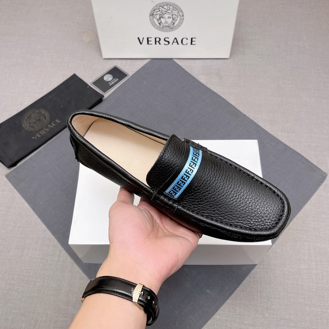 Black leather loafer with blue logo band on upper, beige lining visible