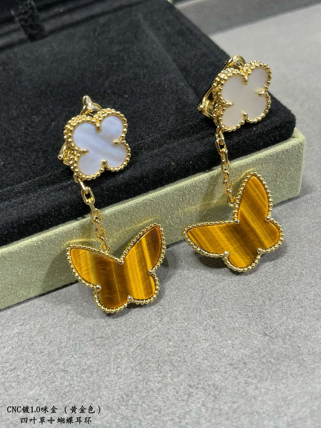 Van Cleef & Arpels earrings showing white clover studs and yellow butterfly dangles