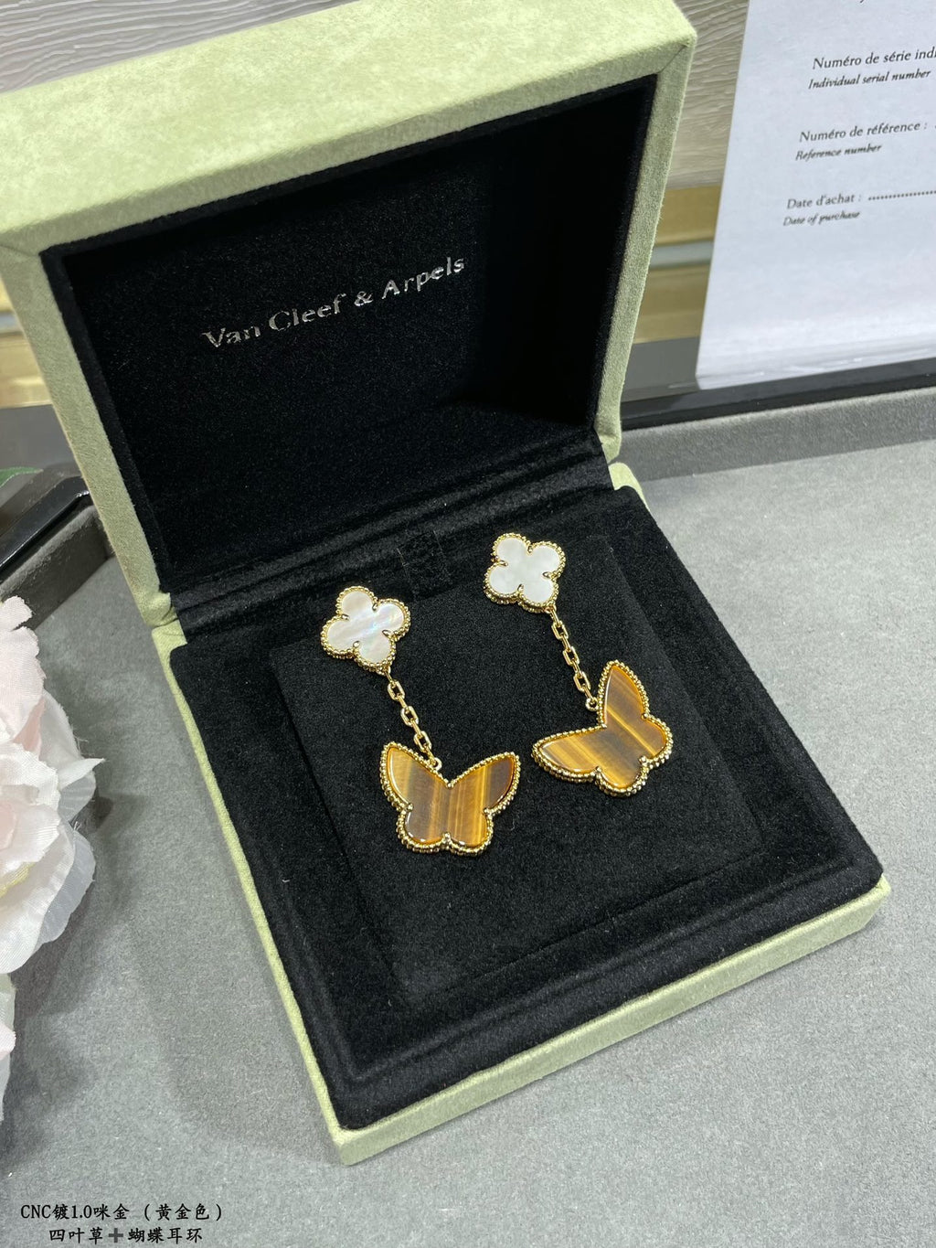 Van Cleef & Arpels butterfly dangle earrings with white clover flowers, shown in box