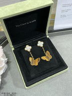 Van Cleef & Arpels butterfly dangle earrings with white clover flowers, shown in box