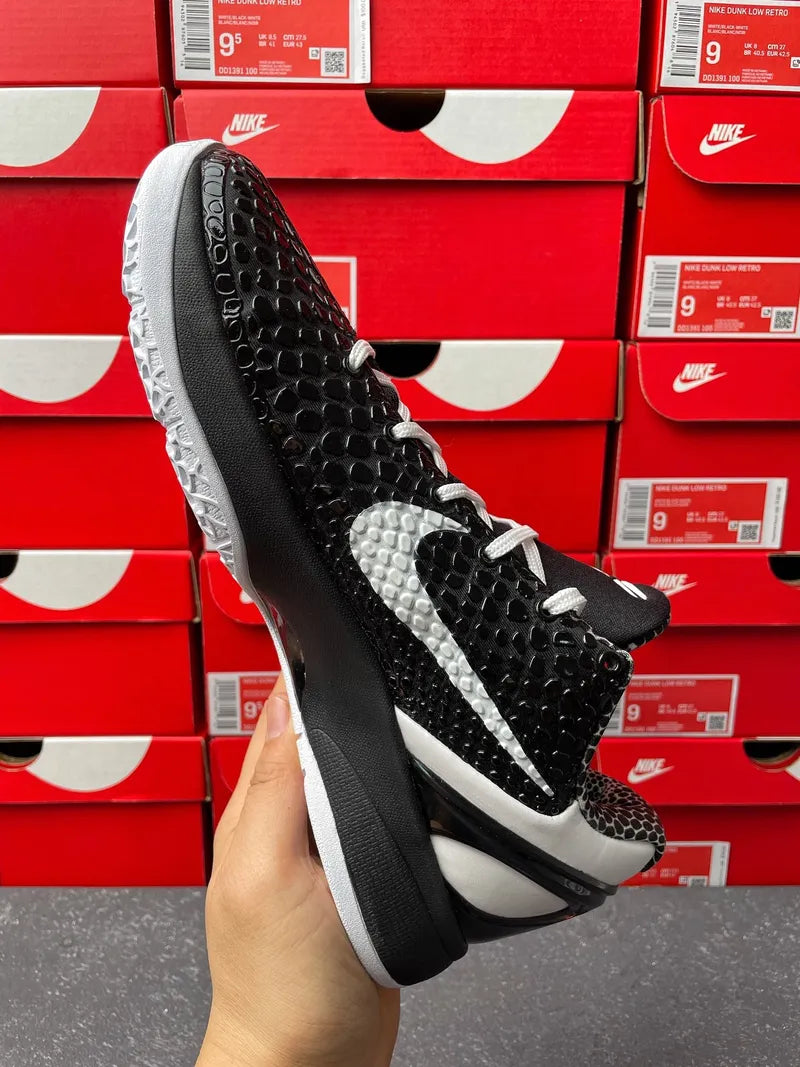 Nike basketball shoe 3/4 angle in black with white swoosh and gray midsole