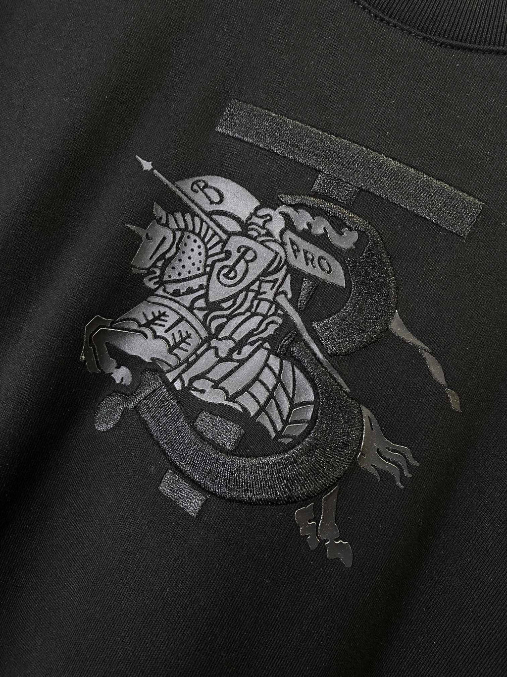 Black Burberry T-shirt with dark front graphic patch on the chest