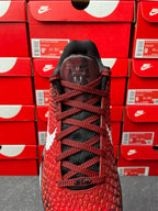 Red athletic shoe back view with black laces and black heel tab