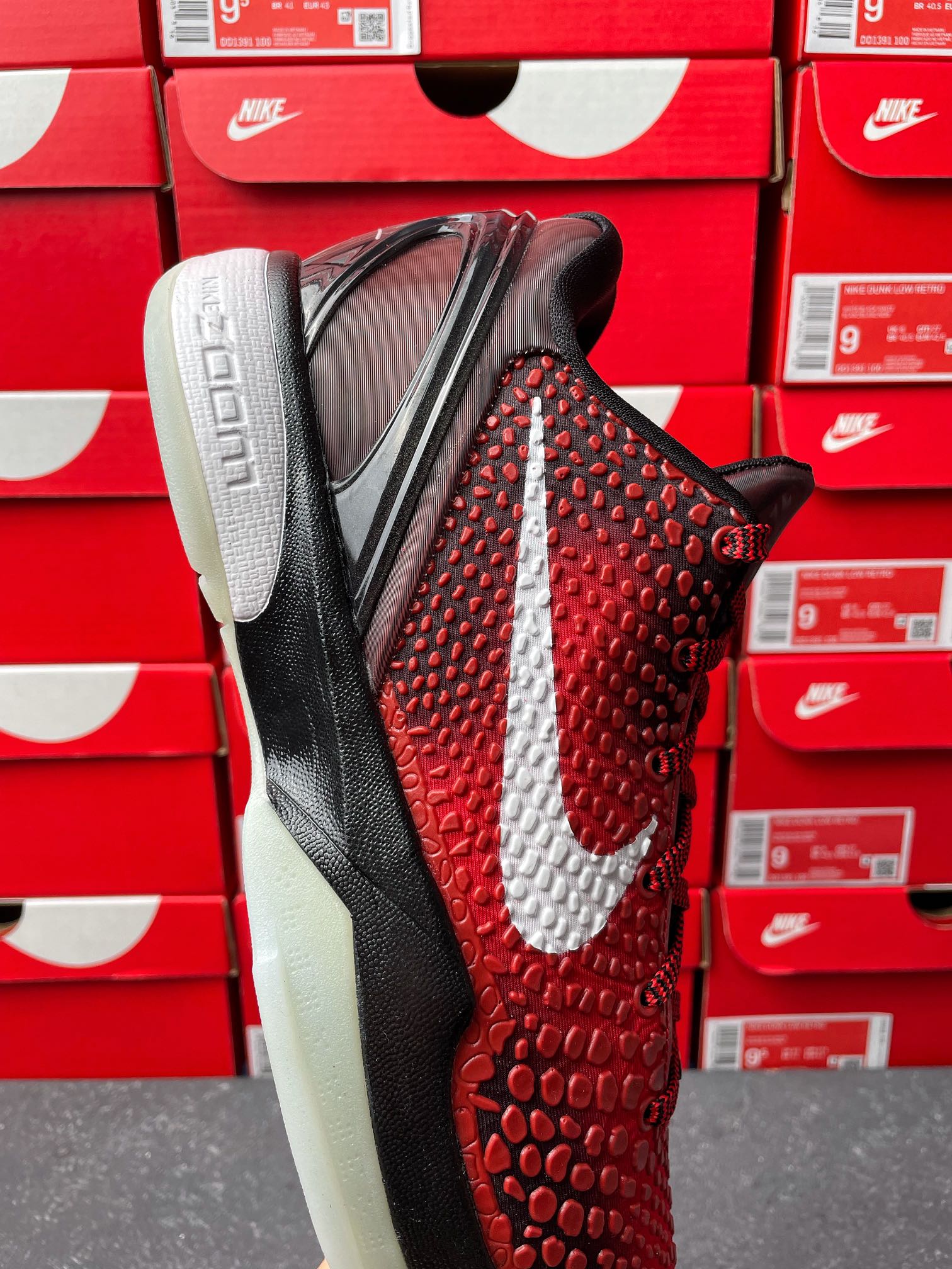 Red textured athletic shoe with white swoosh, black heel panel, and black laces