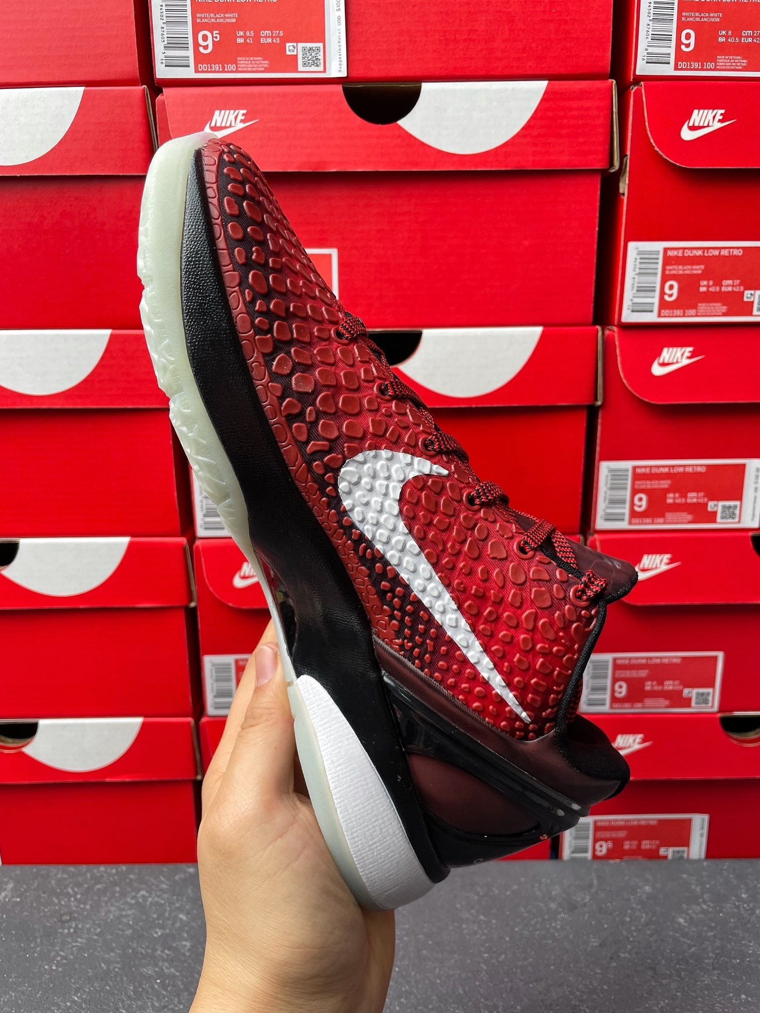 Red athletic shoe front side view with textured pattern, white swoosh, and black sole