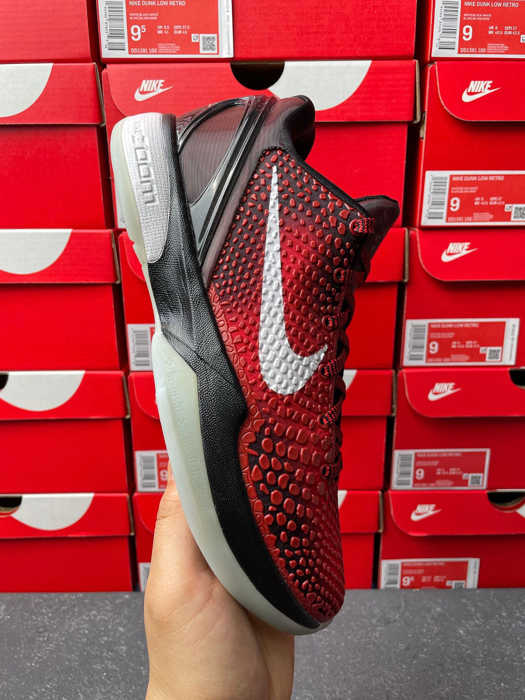 Red textured athletic shoe side view with white swoosh and black midsole