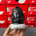 Black heel and upper of athletic shoe with white script logo and white midsole