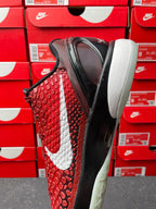 Red athletic shoe with white swoosh, black sole, and rounded white midsole
