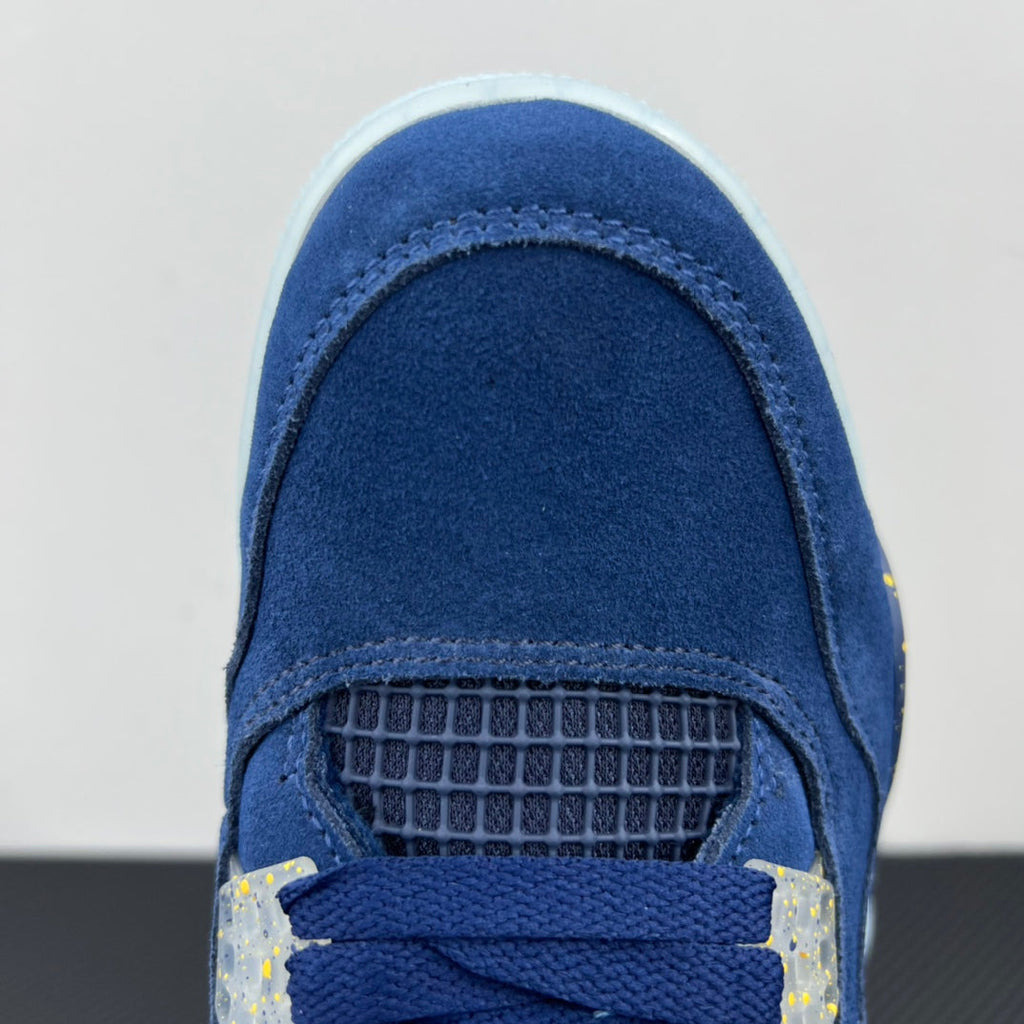 Air Jordan 4 toe close-up in blue suede with mesh panel and yellow speckled accents
