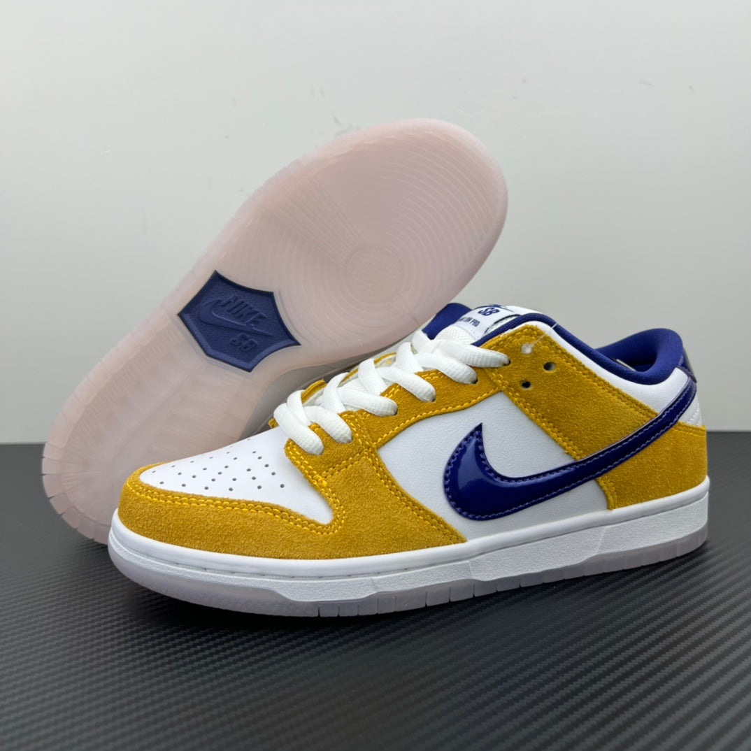 Nike Dunk SB Low Pro sneakers showing toe and outsole, white and gold upper with navy swoosh