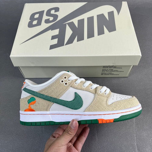 Tan and white low-top sneaker with green swoosh and orange detail, green sole.