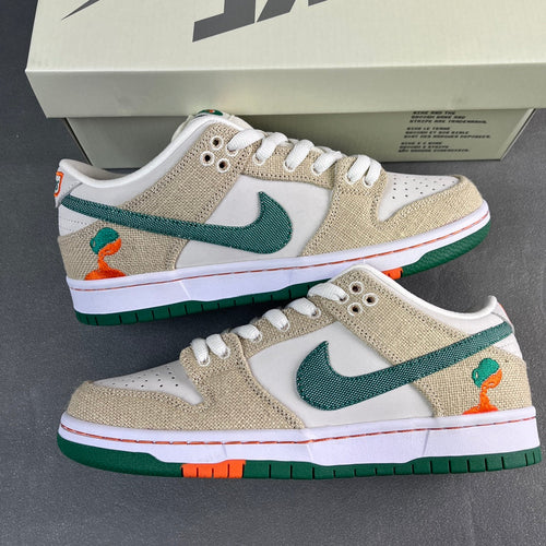 Tan and white low-top sneakers with green swoosh and orange accents, green sole.