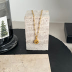 Gucci pendant necklace with gold chain and round logo charm on display