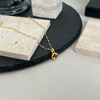Gucci pendant necklace with gold chain and round logo charm at the end