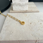 Gucci pendant necklace with gold chain and round logo charm on stone