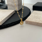 Gucci pendant necklace with gold chain and round logo charm centerpiece