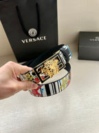 Versace belt held with multicolor strap and gold lion buckle on dark base