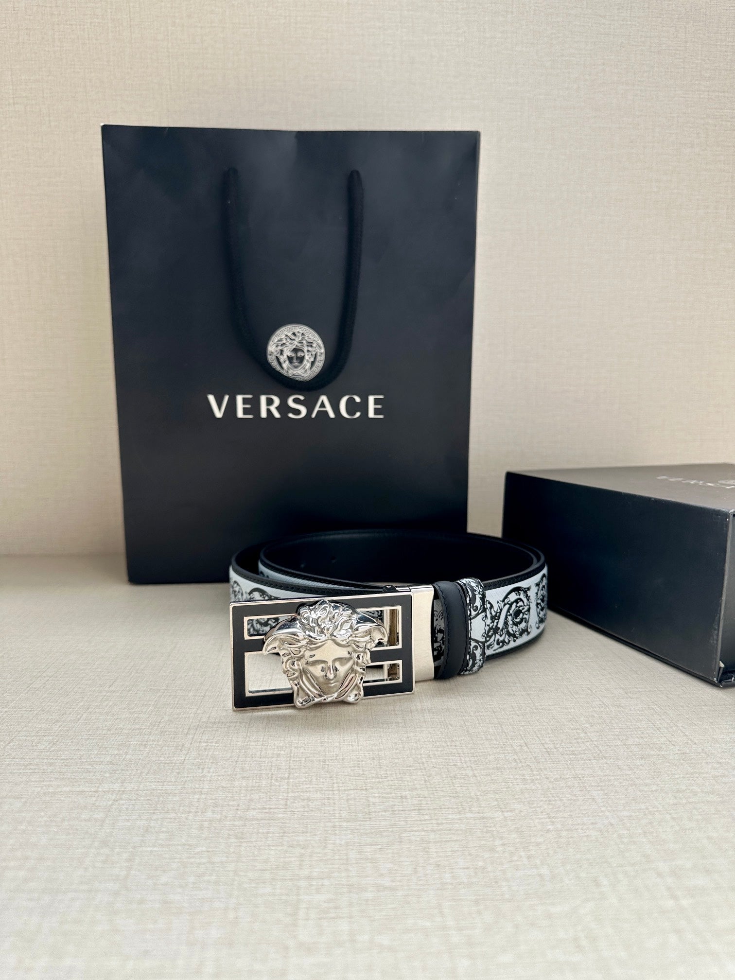 Designer belt with patterned strap and silver Medusa buckle