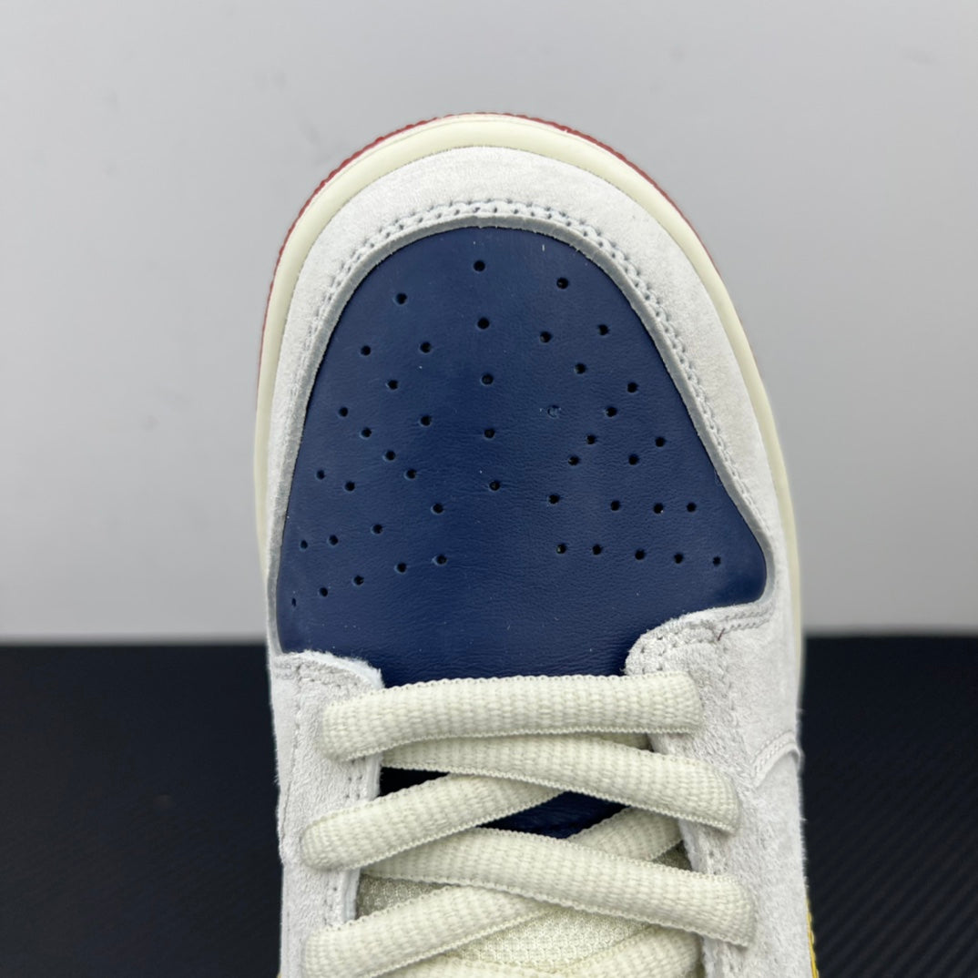 Front view of low-top sneaker showing navy perforated toe and white laces.